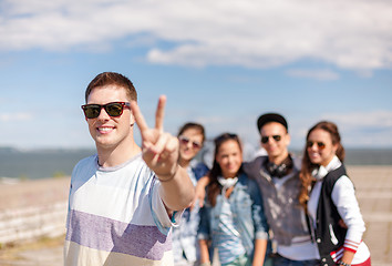 Image showing teenage boy with sunglasses and friends outside