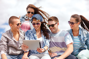 Image showing group of smiling teenagers looking at tablet pc