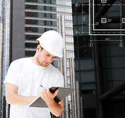 Image showing male architect in helmet looking at blueprint