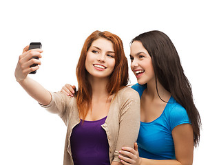 Image showing two smiling teenagers with smartphone