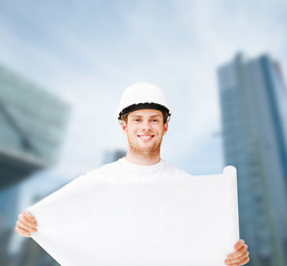 Image showing male architect in helmet looking at blueprint