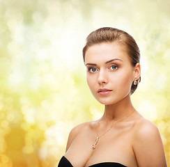 Image showing woman wearing shiny diamond earrings and pendant