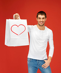 Image showing smiling man with shopping bags and heart on it