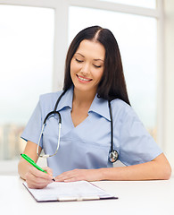 Image showing female doctor or nurse writing prescription