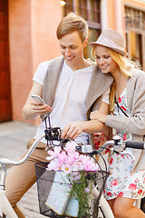 Image showing couple with smartphone and bicycles in the city