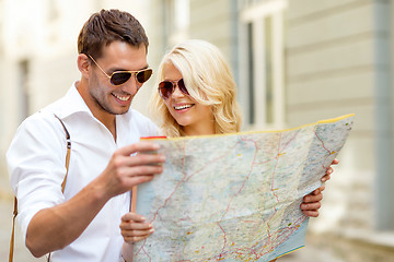 Image showing smiling couple in sunglasses with map in the city