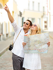 Image showing smiling couple in sunglasses with map in the city