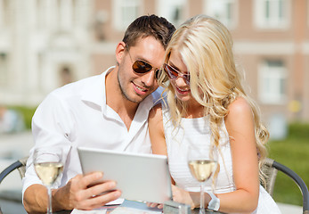 Image showing couple looking at tablet pc in cafe