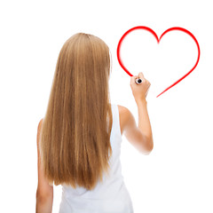 Image showing girl in shirt drawing heart on virtual screen