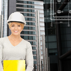 Image showing female contractor in white helmet with files