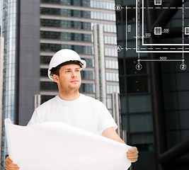 Image showing male architect in helmet looking at blueprint