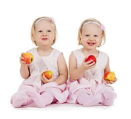 Image showing two identical twin girls playing with apples