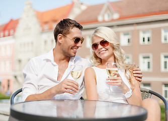 Image showing smiling couple in sunglasses drinking wine in cafe