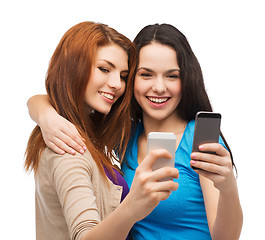 Image showing two smiling teenagers with smartphones