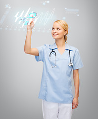 Image showing smiling doctor or nurse pointing to cardiogram