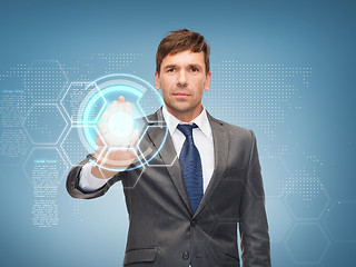 Image showing attractive buisnessman working with virtual screen