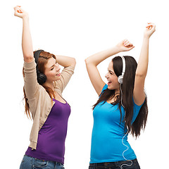 Image showing two laughing girls with headphones dancing