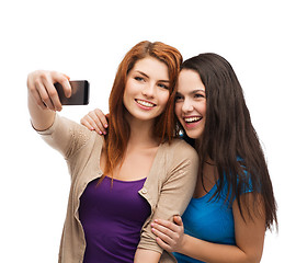 Image showing two smiling teenagers with smartphone