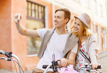 Image showing couple with bicycles taking photo with camera