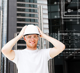 Image showing male architect in white helmet with safety glasses