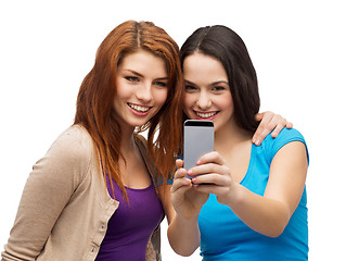 Image showing two smiling teenagers with smartphone