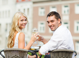 Image showing smiling couple drinking wine in cafe