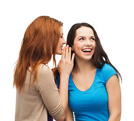 Image showing two smiling girls whispering gossip