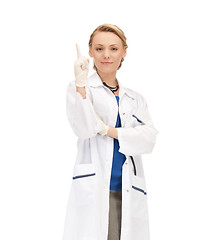 Image showing smiling female doctor pointing her finger up