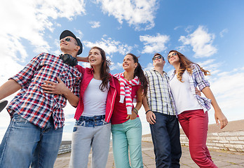 Image showing smiling teenagers in sunglasses hanging outside