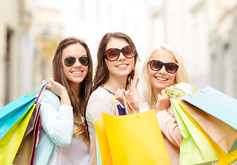 Image showing three smiling girls with shopping bags in city