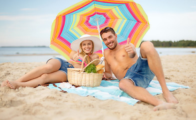 Image showing smiling couple sunbathing on the beach