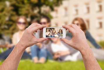 Image showing close up of hands making picture of group of teens