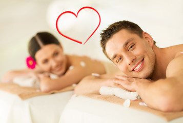 Image showing smiling couple lying on massage table in spa salon