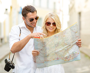 Image showing smiling couple in sunglasses with map in the city