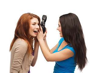 Image showing two laughing teenagers sharing headphones