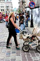 Image showing mother with perambulator walking along the street