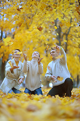 Image showing Beautiful family throw autumn leaves