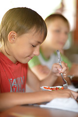 Image showing Little boy eating at home