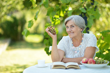 Image showing Woman with grapes and book