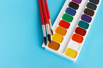Image showing brushes for watercolors paints for children on blue background
