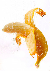 Image showing open banana on a white background with water drops