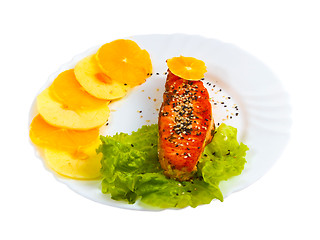 Image showing fried fish salmon with orange and apple leaf lettuce on plate is