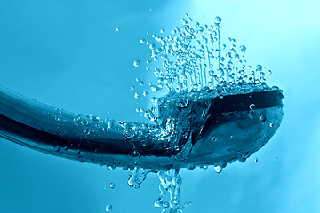 Image showing fresh shower and drops and sprays water on a blue background tex