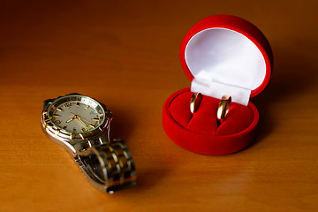 Image showing wedding ring in a box and watches on the table