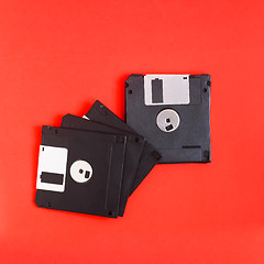 Image showing floppy disk magnetic computer data storage support on a red back