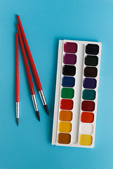 Image showing brush for watercolors and watercolor paints for children on a bl