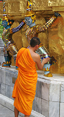 Image showing Monk inspects a statue at the Grand Palace, Bangkok, Thailand -