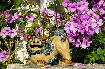 Image showing Shisa figure and pink flowers