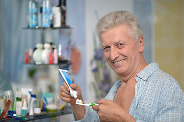 Image showing Old guy brushing teeth