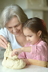 Image showing Little girl kneading dough with grandmother